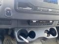 Dashboard of a 2022 Mercedes-Benz Sprinter featuring control buttons air conditioning settings and cup holders with a cigarette resting inside one of the holders