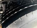 Close-up of a 2016 Freightliner 108SD tire showing its tread pattern and surface texture with water droplets отражая свет