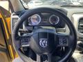 The interior of a 2015 RAM 1500 showing the steering wheel with the Dodge logo and dashboard gauges including speedometer and fuel level indicators