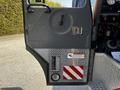 A close-up of the door of a 2006 Emergency One Fire Truck featuring a stainless steel panel with warning labels and a circular light at the bottom