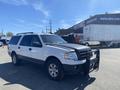 A white 2013 Ford Expedition with a black front grille guard parked at a dealership