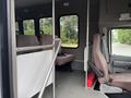 Interior view of a 2014 Ford E-350 showing two rows of seating with a wheelchair accessible area and safety features