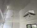 The ceiling of a 2025 Shuttle Office featuring smooth white surfaces and an air conditioning unit with vents and lights integrated into the design
