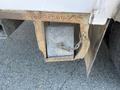 A rusted metal box mounted on the undercarriage of a 2007 International 7300 secured with a chain