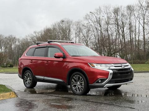 A red 2016 Mitsubishi Outlander parked with a sleek design featuring chrome accents and alloy wheels