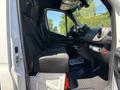 Side view of a 2019 Mercedes-Benz Sprinter interior showing the driver's seat with a black fabric covering and dashboard details