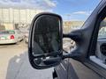 A side mirror of a 2011 Ford Econoline showing reflections and a black frame