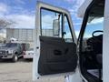 A 2011 International 4300 truck with an open driver's door revealing the interior controls and seat
