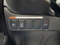 A panel with five buttons in a 2016 Mitsubishi Outlander featuring icons for vehicle features and a warning label about the tailgate path