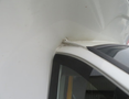 Close-up of a 2020 Chevrolet Express showing the seam between the roof and the windshield with visible wear and possible damage