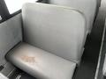 A gray bus seat with a small stain on the surface