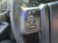 Close-up of the steering wheel controls of a 2014 Ford F-350 SD featuring buttons for cruise control and information settings