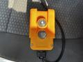 A yellow control switch with two buttons marked with an upward arrow and an N symbol is displayed on a textured surface