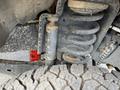 Close-up of the suspension system of a 2017 Ford F-250 SD showing a coil spring and shock absorber with a rugged tire in the foreground