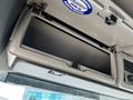 Open glove compartment of a 2005 Volvo VND 122 with a light grey interior and a small plastic divider inside