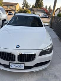 A 2011 BMW 7-Series sedan in white with a distinctive kidney grille and sporty front design