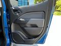The interior door panel of a 2021 Chevrolet Colorado features a sleek design with controls and storage compartments in black plastic and fabric accents