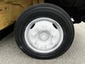 A close-up of a white rim with bolts mounted on a black tire of a 2006 Hino 268 truck
