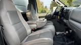 Interior view of a 2007 Ford F-550 showing two gray cloth seats and a center console with storage space