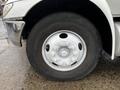 Close-up view of a 2011 International DuraStar 4300 truck tire mounted on a silver wheel with visible lug nuts and a textured black tire surface