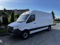 A 2022 Mercedes-Benz Sprinter van with a white body and black accents parked at an angle showcasing its front and side design