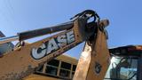 A 2015 Case 580 backhoe loader with a distinctive yellow paint job featuring the brand name "CASE" prominently displayed on the arm