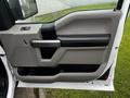 Interior door panel of a 2017 Ford F-150 featuring a gray and black color scheme with a door handle and control buttons
