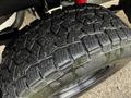 Close-up view of a rugged tire on a 2022 Toyota Tacoma showcasing deep treads designed for off-road traction