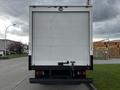 A white 2022 Isuzu NPR truck with a boxy design and a rear loading door facing the viewer
