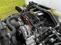 An engine compartment of a 2021 Mitsubishi FE showing a detailed view of the engine with various components and wiring visible