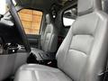 Interior view of a 2011 Ford Econoline showing two gray vinyl seats and the steering wheel