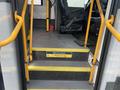 Interior steps of a 2018 Chevrolet Express with yellow handrails and caution signs indicating to welcome aboard and watch your step