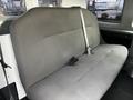 Interior view of a 2011 Ford Econoline showing a large gray fabric bench seat with a seatbelt