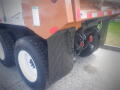 A 2016 International WorkStar 7500 truck with a brown rear body and visible black tires featuring a tread pattern and mud flaps attached to the rear wheels