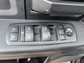 A close-up view of the driver's side control panel in a 2015 RAM 1500 featuring window control buttons and a circular dial for adjusting mirrors