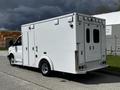 A 2013 Chevrolet Express van with a white exterior and a boxy body design featuring side and rear doors and rear lights