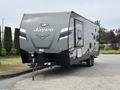 A 2021 Jayco Jay Flight travel trailer with a sleek gray exterior featuring the Jayco logo on the front and a hitch at the base