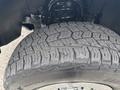 Close-up of a rugged tire with an aggressive tread pattern mounted on a 2016 GMC Sierra 1500 truck