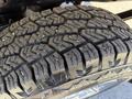 Close-up of a rugged tire with deep treads designed for off-road capability on a 2016 GMC Sierra 1500