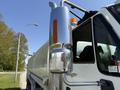 A 2009 International 7500 truck with a shiny chrome side mirror and a prominent exhaust stack