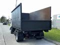 A 2009 Ford LCF 550 truck with a large black cargo bed is parked on the side of the road