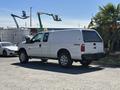 A white 2014 Ford F-250 SD with an extended cab and a truck bed cover parked in a lot