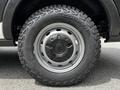 Close-up view of a rugged tire mounted on a 2022 Ford Transit showcasing deep treads and the Cooper tire brand logo