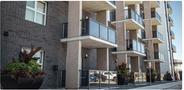Two-bedroom two-bathroom sublet featuring a modern exterior with balconies and large planters at the entrance