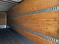Interior of a 2021 Hino 338 truck showing wooden walls with metal track system for securing cargo