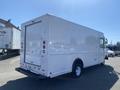 2012 Ford Econoline box truck with a white exterior and rear roll-up door parked in a commercial area