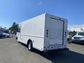 A white 2012 Ford Econoline cargo truck viewed from the rear showing the large cargo door and rear lights