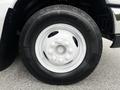 A close-up of a white spare tire mounted on a black wheel of a 2013 Ford Econoline with a textured tire tread