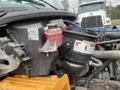 Close-up of the engine compartment of a 2007 Freightliner B2 showing various components including a low fluid reservoir and an air filter assembly