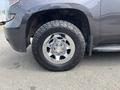 Close-up of a chrome wheel and tire on a 2016 Chevrolet Tahoe showcasing an all-terrain tread pattern and the vehicle's silver bowtie emblem on the center cap